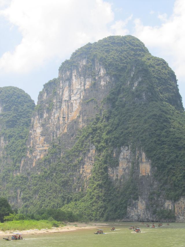 惊叹一座石头山竖立在河边,还有顽强的见缝插针装扮着石山.