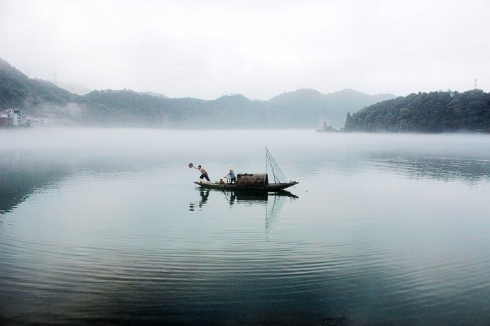 晨雾不高不低,笼罩在江面上白茫茫一片,水中央一艘小渔,渔夫在晨雾中
