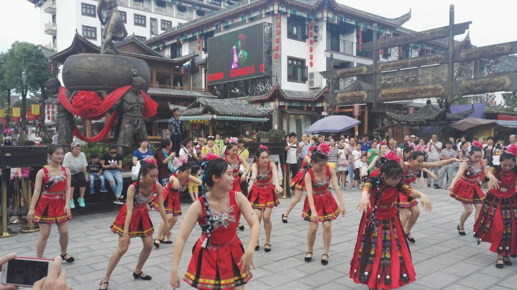 她们跳好后可以一起围绕后面的铜鼓跳摆手舞