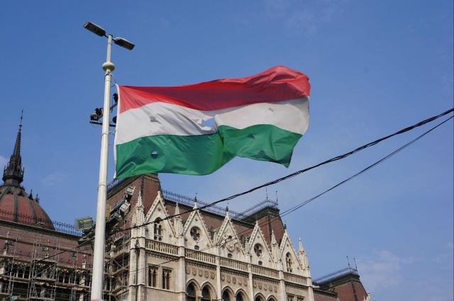 国会大厦外面升着一面被挖破洞的国旗,寓意着摆脱了苏联的政治控制.