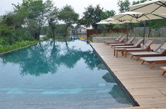 全开放的竹亭,任你在天地间品读书籍,感受阳光雨露;湛蓝的无边泳池,任