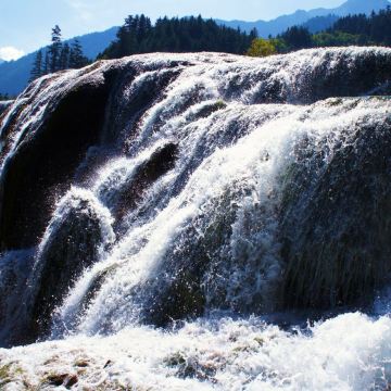 澎湃湍急的瀑布直泻而下,水花四溅中折射出一个个如同烟花般的光影